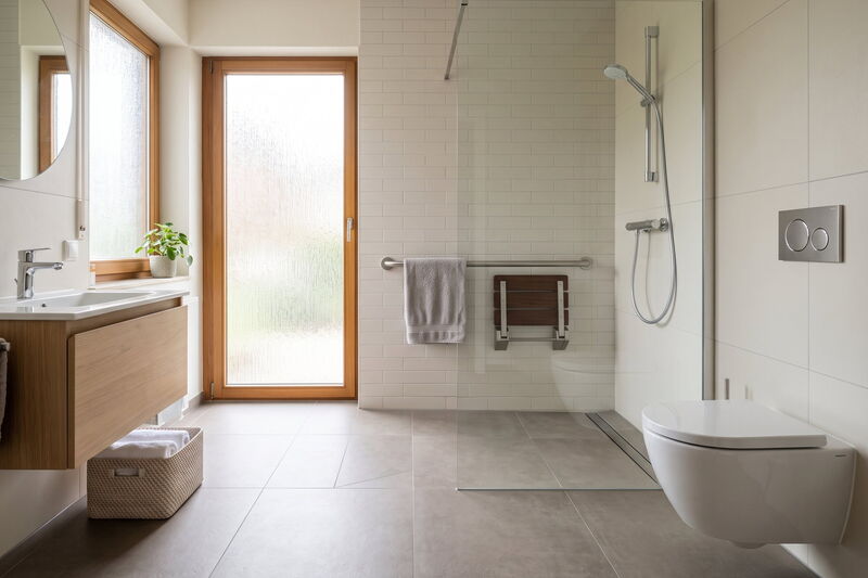 Barrierefreies Bad mit bodengleicher Dusche, Duschklappsitz und Haltegriff